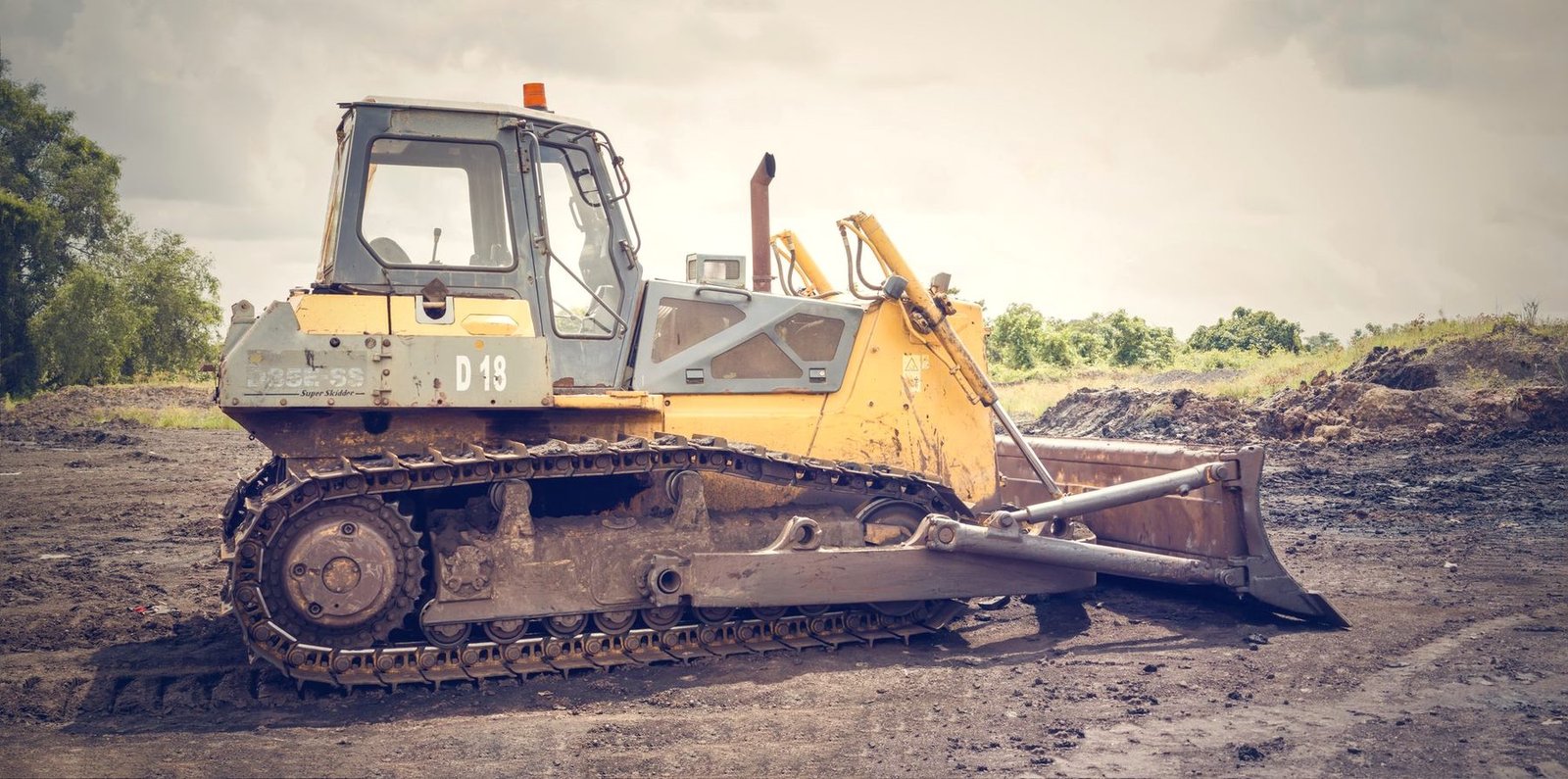 A yellow crawler dozer on bare graded dirt